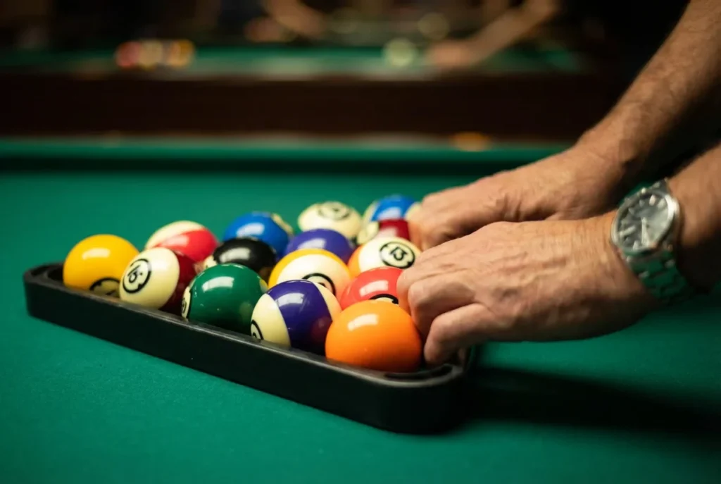 Игрок толкает бильярдные шары пальцами вперед в стойке, чтобы устранить зазоры для плотного брейка